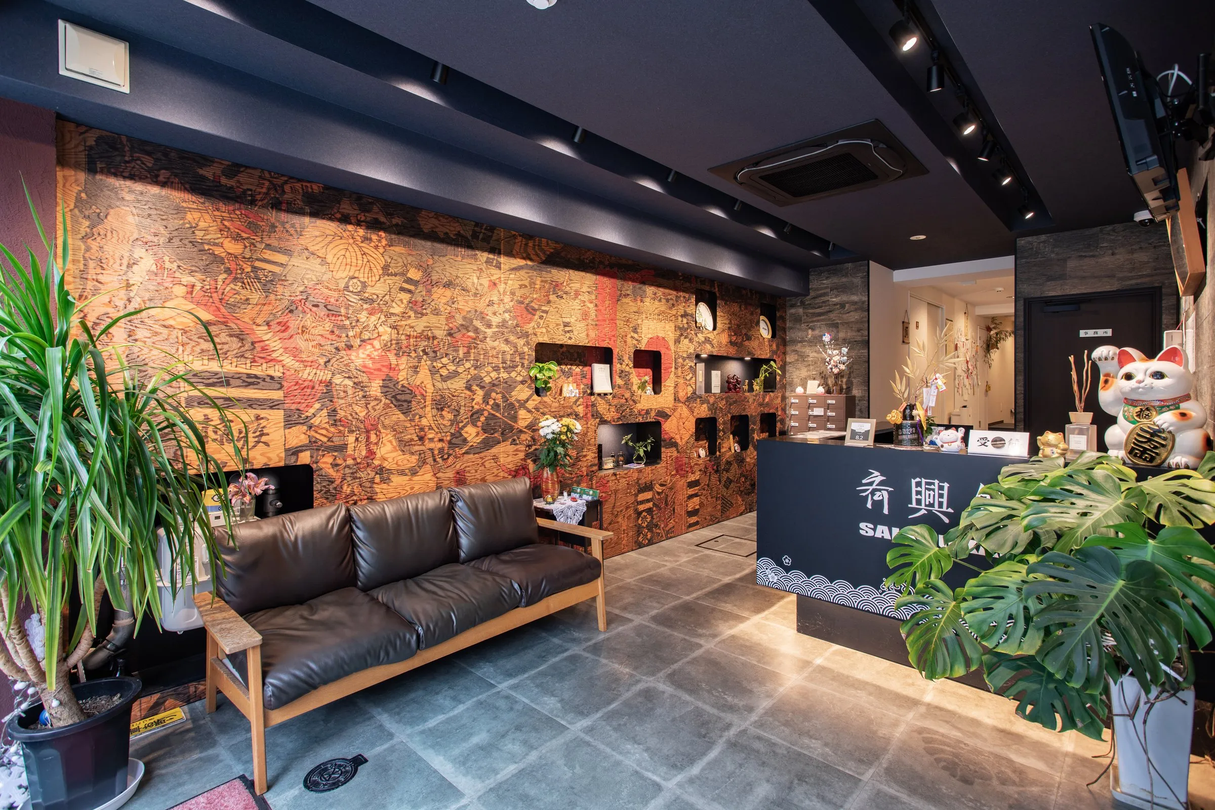 Lobby lounge with patterned walls, a leather sofa and plants